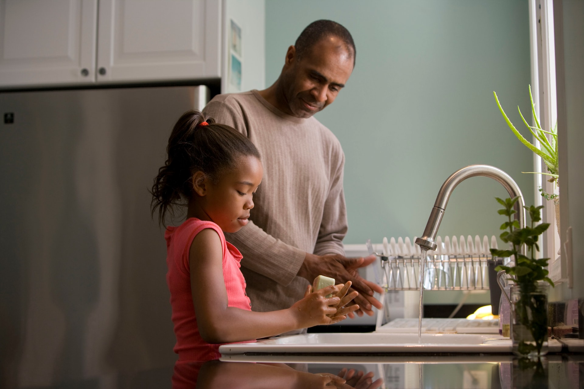 parent washing dishes with child for Adopt a Stepchild in Ca case